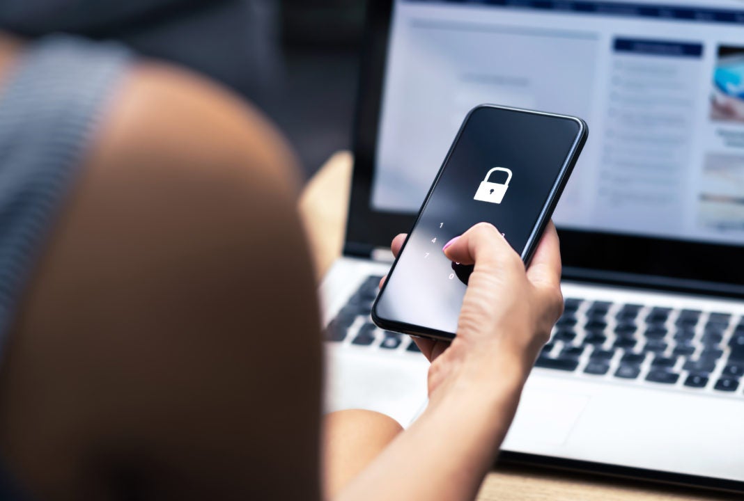 Image of person holding phone with security screen meant to symbolize VPN connection.